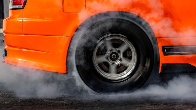 Foto pneumático de rodas de carro com fumaça brancapneumético de roda de carro com fumaça do pneu giratório