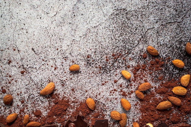 Pó de cacau de chocolate escuro de amêndoas em um fundo de concreto neutro cinza