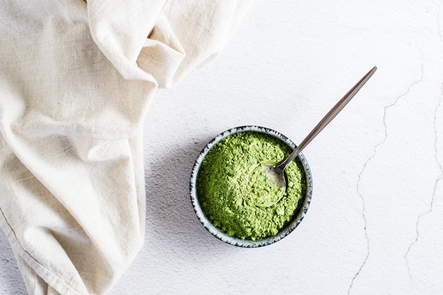 Pó de chá matcha verde orgânico em uma tigela e uma colher na mesa Fonte de vitaminas e antioxidantes Vista superior