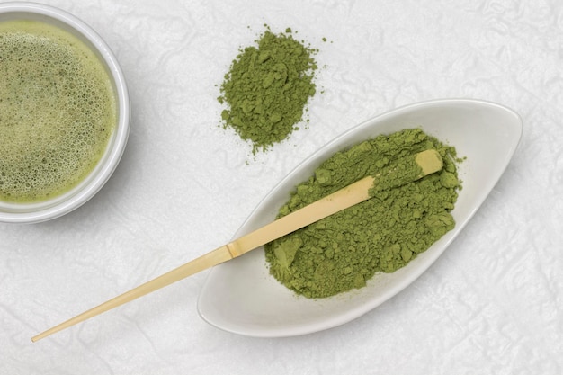 Pó de chá verde matcha e colher medidora de bambu em uma tigela Chá matcha em uma tigela