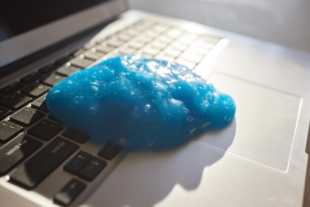 Foto pó de limpeza de gel macio azul no teclado conceito de limpeza do teclado do computador limpeza do escritório