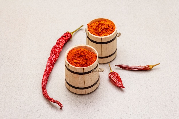 Pó de páprica doce e quente vermelho magiar. tempero tradicional para cozinhar alimentos nacionais, diferentes variedades de pimenta seca. barris de madeira, concreto de pedra