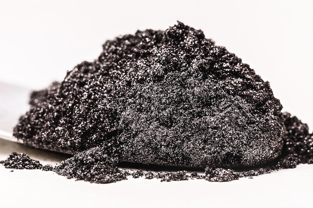 Pó de pigmento preto para uso industrial ou cosmético fundo branco isolado em macro fotografia de placa de petri