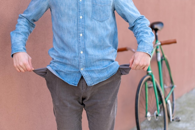 Pobre joven estudiante bolsillos vacíos Crédito para vivienda o educación Último dinero para pagar la deuda Pago de facturas Comprar una bicicleta cara