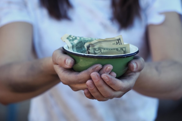 Foto pobre mujer sosteniendo un tazón con dinero