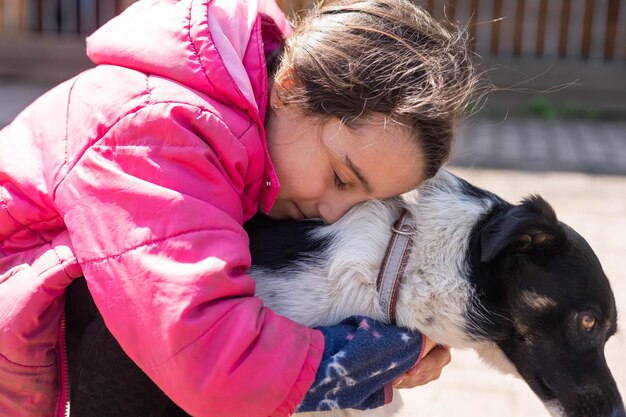 Pobre niña con un perro en el pueblo