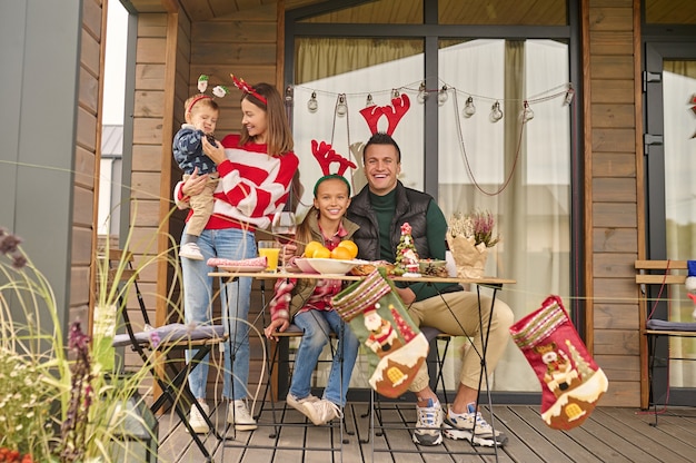Época de Natal. Uma jovem família comemorando o natal em uma casa de campo