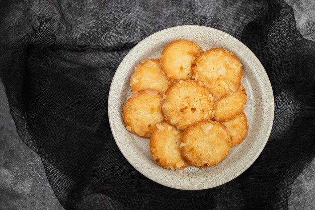 Pocas galletas caseras con almendras en un plato pequeño blanco