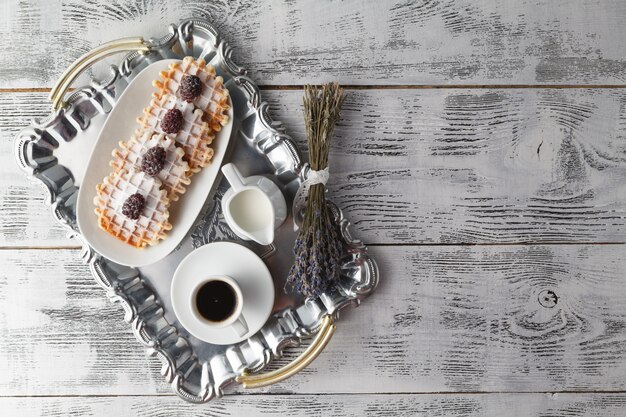 Pocas obleas en la mesa con bayas y café