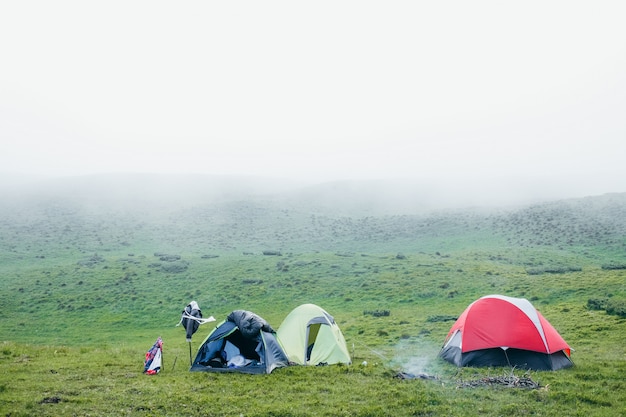 Unas pocas tiendas de campaña en las montañas en un día de niebla