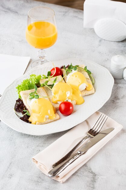 Pochierte Eier mit Gemüse auf Sauerteigtoast lokalisiert auf weißem Marmortisch. Hausgemachtes Essen. Leckeres Frühstück. Selektiver Fokus. Draufsicht.