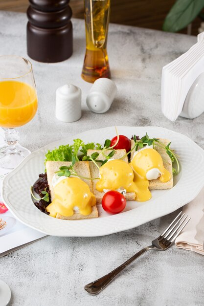 Pochierte Eier mit Gemüse auf Sauerteigtoast lokalisiert auf weißem Marmortisch. Hausgemachtes Essen. Leckeres Frühstück. Selektiver Fokus. Draufsicht.