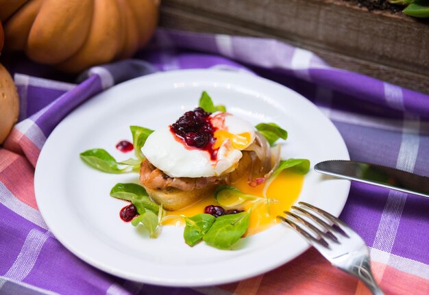 Pochiertes Ei auf Bruschetta mit Speck und Preiselbeermarmelade Feldsalat