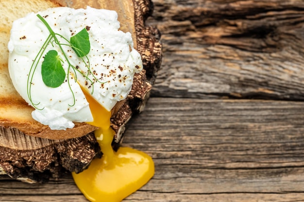 Pochiertes Ei auf Toast auf dem Holztisch Gesundes Essen Keto-Diät-Diät-Mittagessen-Konzept Ansicht von oben