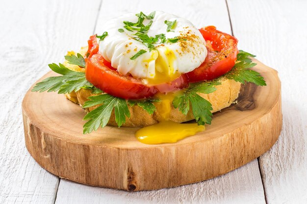 Pochiertes Ei auf Toast mit Tomaten und Petersilie zum Frühstück