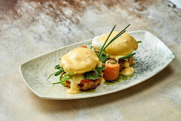 Pochiertes Ei mit Sauce Hollandaise und Lachs in einem Teller. Selektiver Fokus, Nahaufnahme