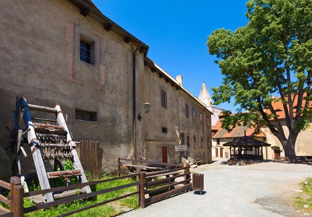 Poço e instrumento de tortura no pátio do castelo medieval Krivoklat, na República Tcheca