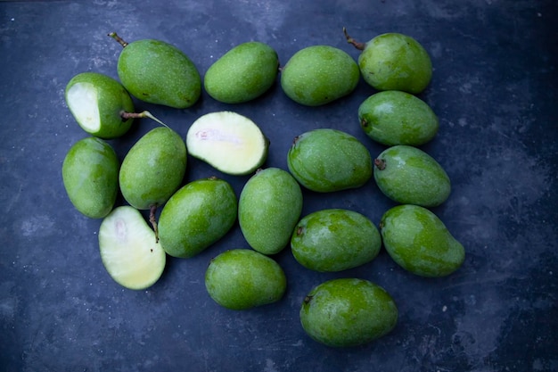 Un poco de mango verde crudo fresco en el piso de concreto