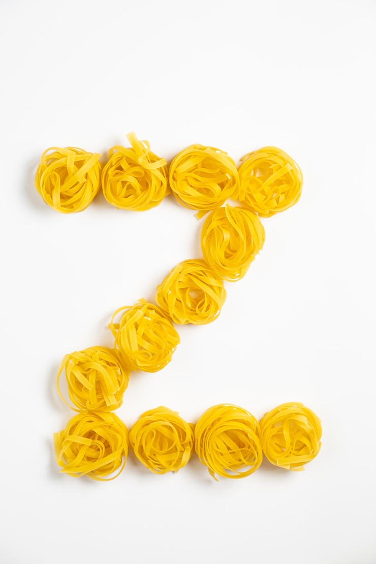 Foto pocos nidos de fettuccine caseros en forma de letra z aislados en fondo blanco