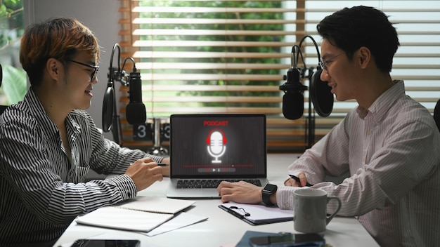 Podcasters de hombres jóvenes que usan podcasts de grabación de auriculares desde el estudio en casa Podcasts de radio blogs y concepto de tecnología