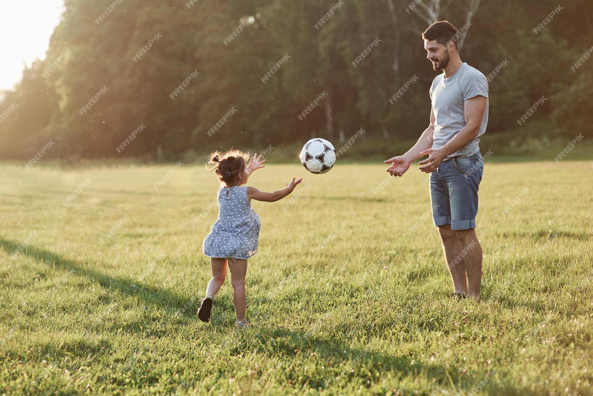 Podemos trapacear às vezes. as mãos são bem-vindas. pai entusiasmado ensina  a filha como jogar seu jogo favorito. é futebol e até as meninas podem jogar.