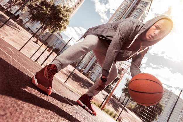 Poder de concentración. Ángulo bajo de un serio hombre concentrado jugando baloncesto