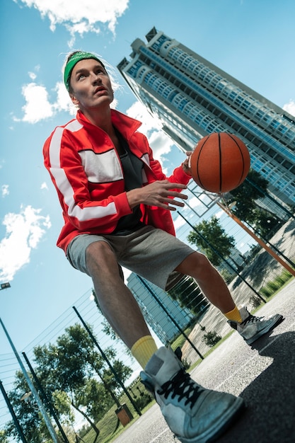 Poder de concentración. Ángulo bajo de un joven serio concentrándose en el juego mientras jugaba baloncesto