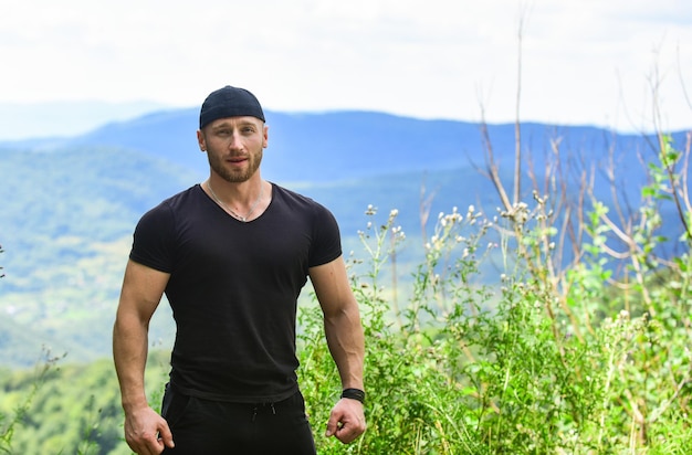 Poder masculino Turista andando montanha colina Conceito de caminhada Poder da natureza Descubra o mundo Masculinidade e energia masculina Homem fisiculturista muscular fundo de paisagem de montanha Poder natural