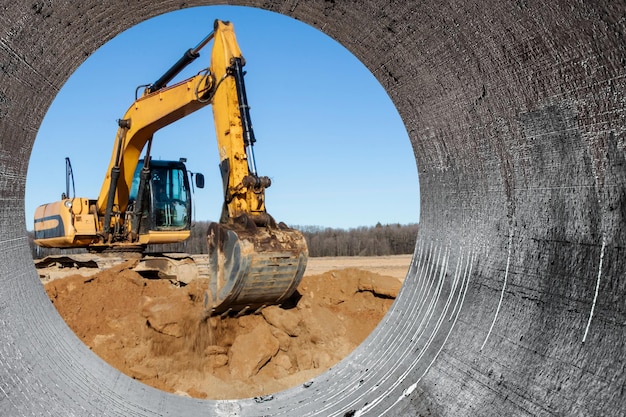 Una poderosa excavadora de oruga cava el suelo contra el cielo azul Movimientos de tierra con equipo pesado en el sitio de construcción