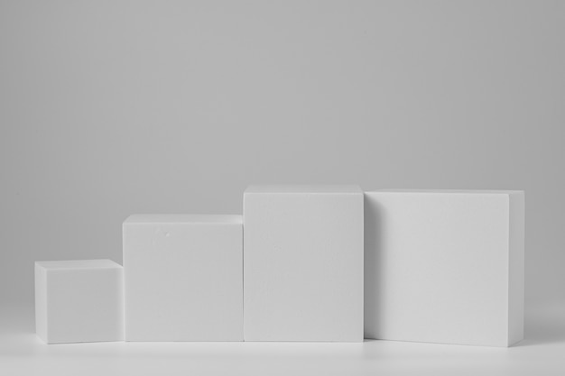 Podio en forma de geometría para una presentación simulada en color gris y estilo minimalista con espacio de copia, diseño de fondo abstracto. Fondo de pie de estante de producto en blanco.