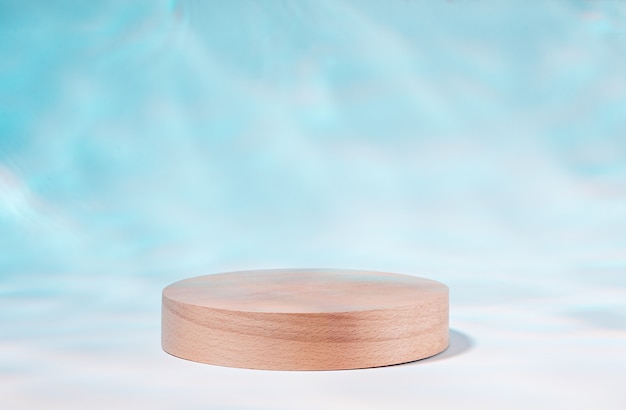 Podio de madera o soporte de producto junto a la piscina con reflejo de la luz solar del agua