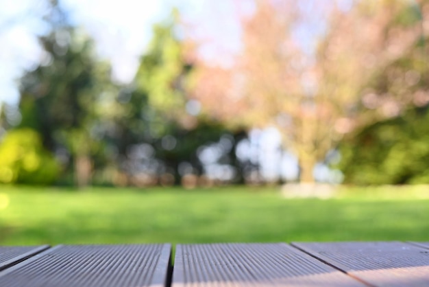 Podio de madera vacía y bokeh desenfocado y fondo borroso de árboles florecientes de jardín con luz solar pr