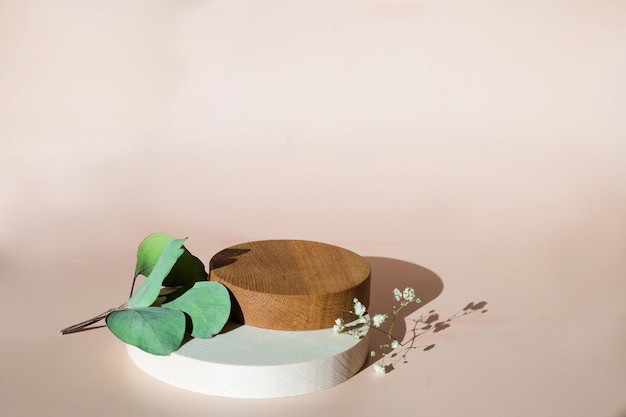 Foto podio de madera vacío fondo beige presentación del producto con flores y hojas