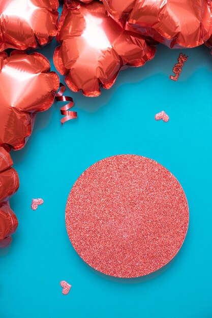 Podio o pedestal y caja de regalo con globos en forma de corazón rojo sobre fondo turquesa Plantilla del Día de San Valentín