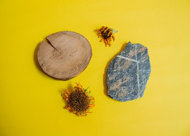 Podio de piedra y madera con girasoles. Vista superior del escaparate vacío para productos cosméticos.