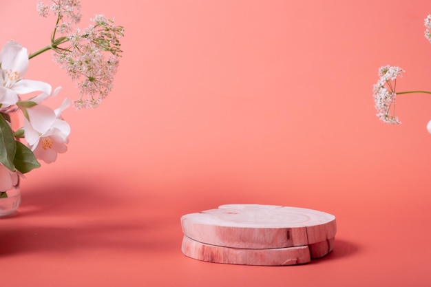 Podios cosméticos vacíos de pedestal de madera de belleza mínima natural sobre fondo rosa con flores para p