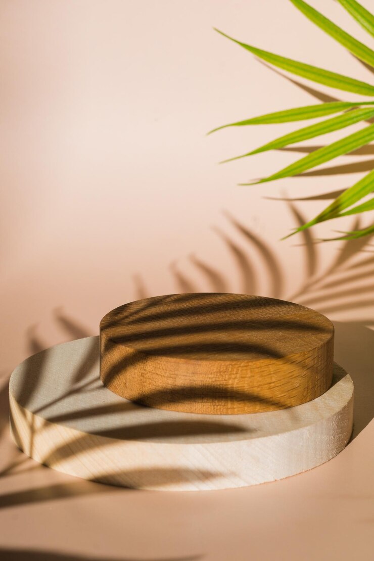 Podium de madera vacío con fondo beige Presentación del producto con hojas y sombras de árboles tropicales