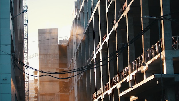 Poeira do local de construção voando no ar pendurando fios no pôr do sol em primeiro plano