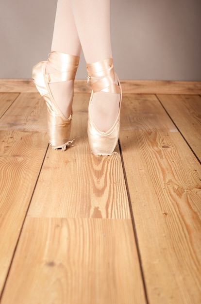 Foto pointes da bailarina clássica no assoalho de madeira