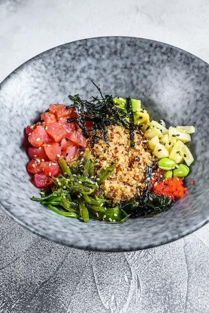 Poke bowl con atún crudo y verduras. Plato hawaiano. Concepto de alimentación saludable Fondo gris Vista superior