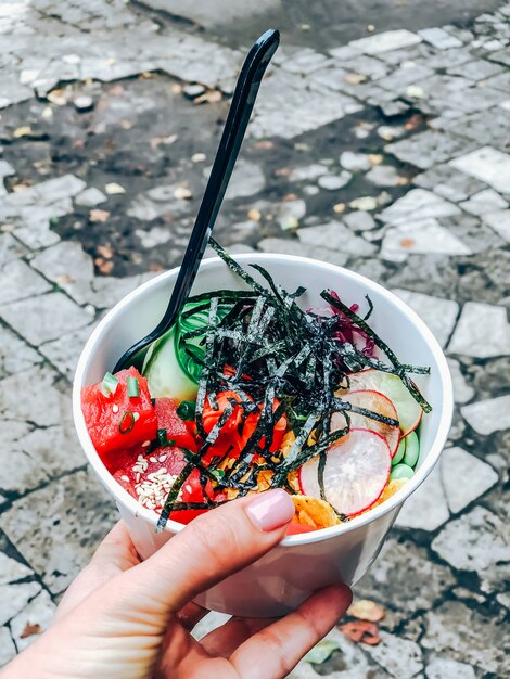 Poke bowl con atún en un recipiente de papel