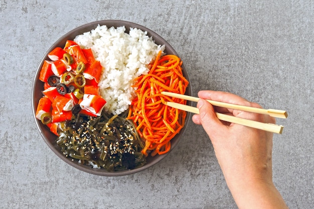 Poke bowl de carne de cangrejo. Comida sana colorida estilizada endecha plana.