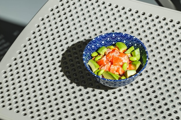 Poke bowl com arroz abacate feijão edamame e salmão defumado luz dura sombra profunda