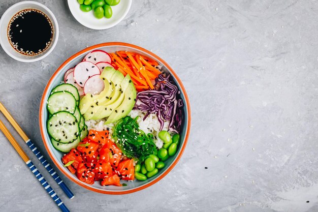 Poke bowl de salmão com arroz abacate algas em conserva cenouras pepino rabanetes e feijão edamame