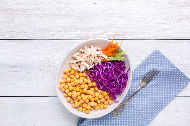 Poke bowl con garbanzos, pollo al vapor, repollo, zanahorias y pepino