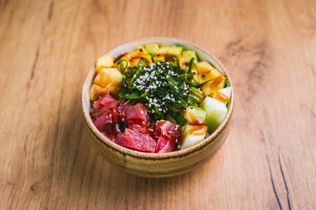 Poke Bowl mit Lachs, Gurke, Avokado, Mango und Chuka Salat