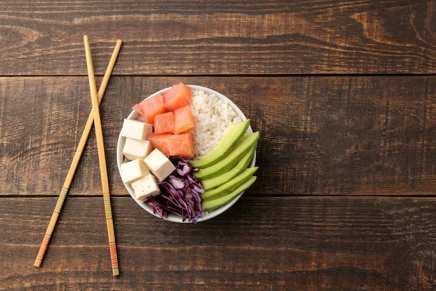 Poke bowl plato de comida hawaiana de arroz, salmón, aguacate, repollo y queso