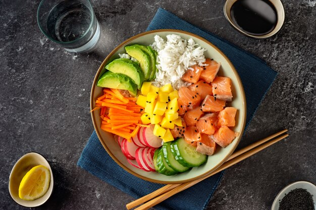 Poke bowl de salmón con aguacate, arroz, zanahorias en vinagre y pepino