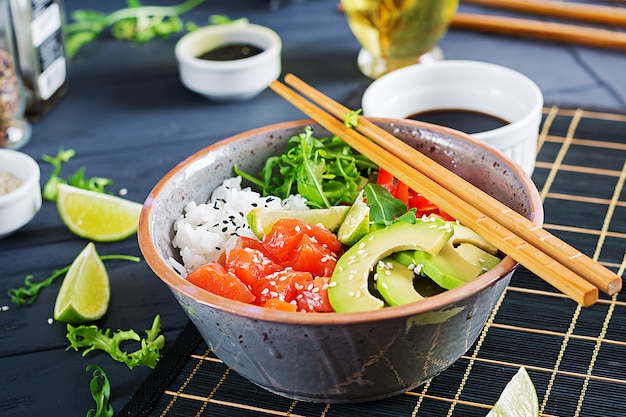 Poke bowl de salmón hawaiano con arroz, aguacate, pimentón, semillas de sésamo y lima.