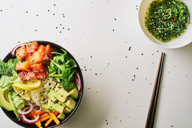 Poke Schüssel mit Lachs, Avocado Essstäbchen